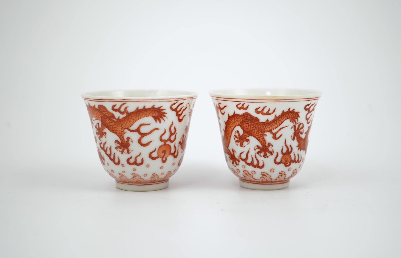 A pair of Chinese iron red ‘dragon’ cups, Guangxu six character mark and probably of the period (1875-1908)